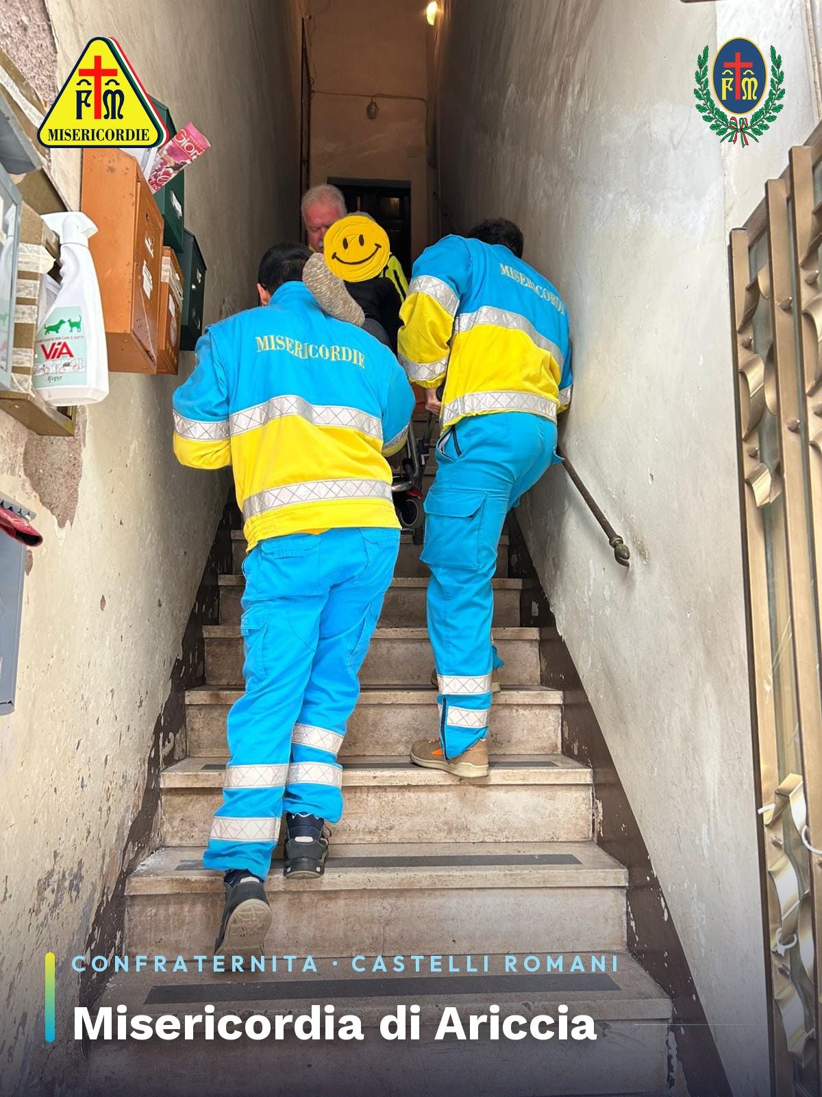 Volontari della Misericordia accompagnano una persona lungo le scale