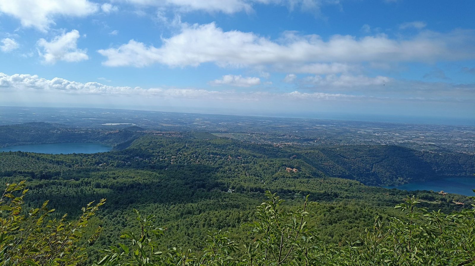 Il panorama dall'Occhialone: i boschi dei Castelli Romani, i laghi di Albano e di Nemi e, all'orizzonte, la pianura fino al mare