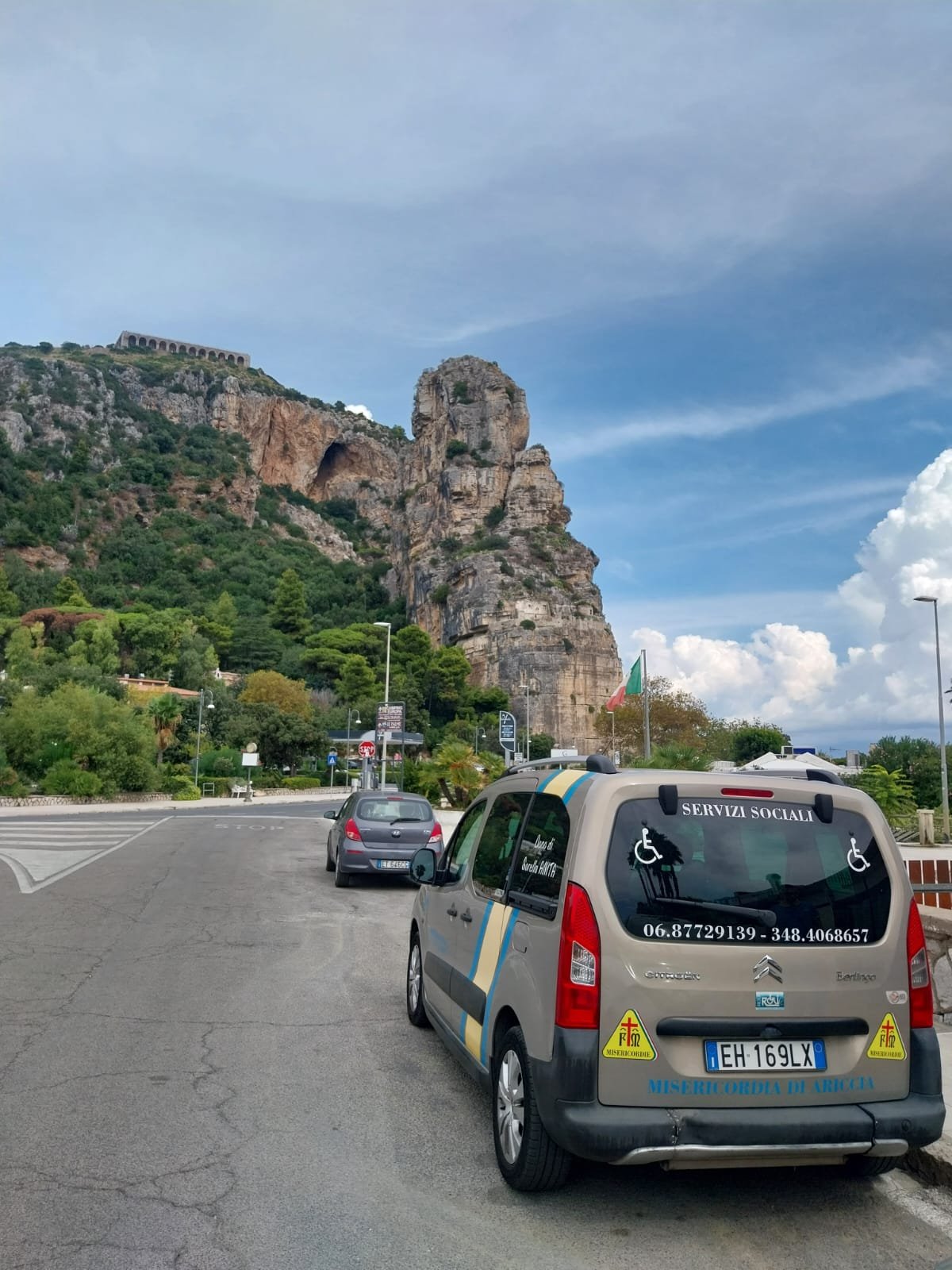 Il Citroën Berlingo dei Servizi Sociali della Misericordia di Ariccia, con la scritta «Dono di sorella Anita» sul finestrino, parcheggiato sotto la rupe rocciosa a picco sul mare durante il trasporto a Fondi