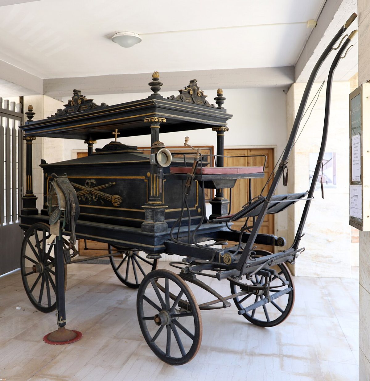 Antico carro funebre in legno scuro della Misericordia di Siena, esposto all'ingresso del camposanto